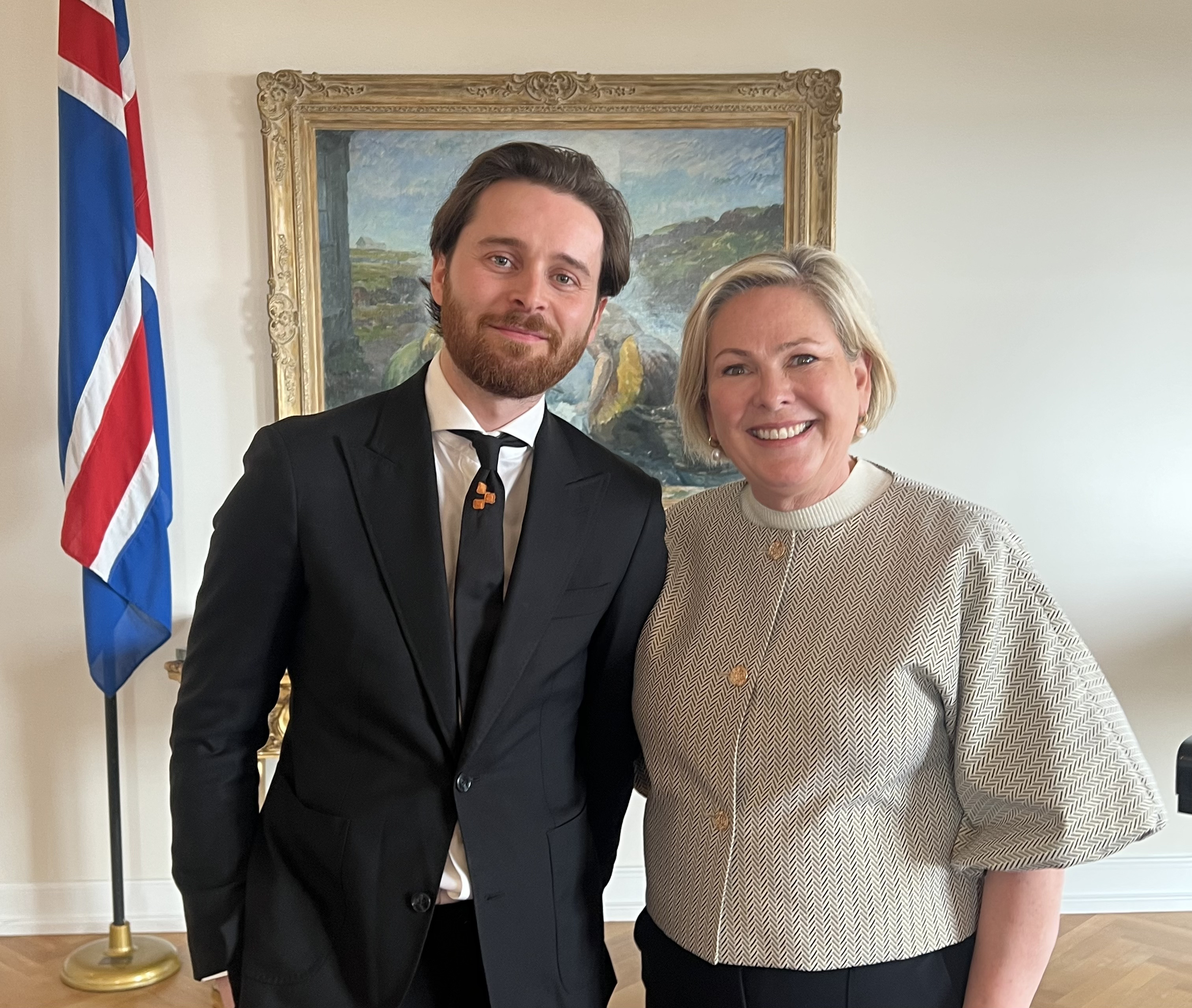 Members of the President of Iceland's "AI for Good" advisory board standing together at the President's residence at Bessastaðir, with the Icelandic flag behind them.